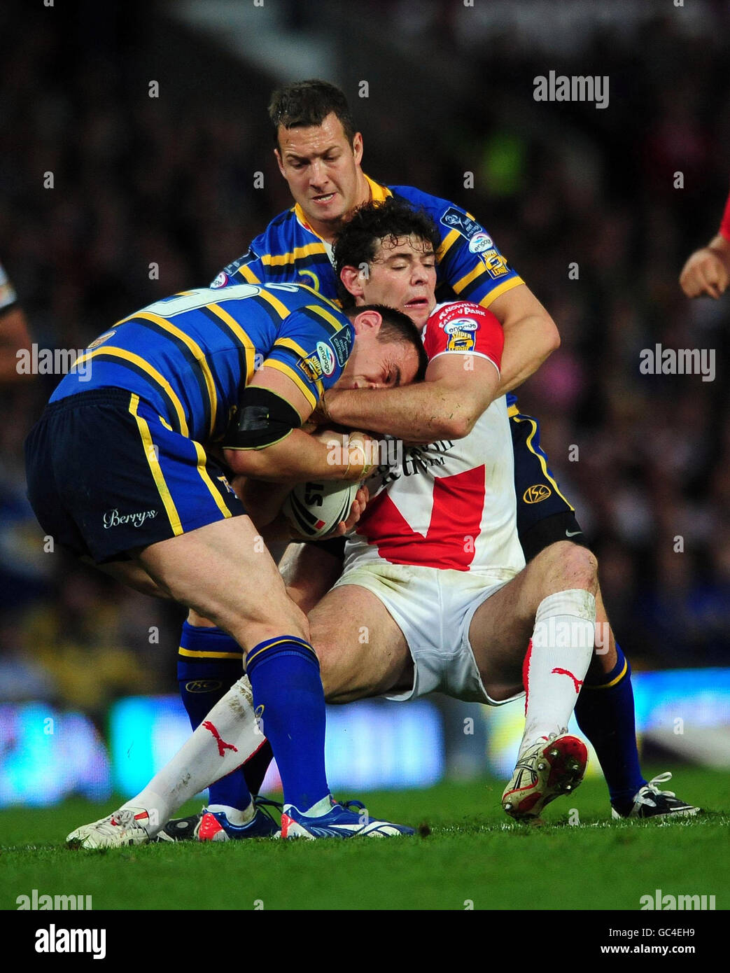 St Helens' Paul Wellens is tackled by Leeds Rhinos3 Kevin Sinfield and Danny Maguire during the Super League Grand Final match at Old Trafford, Manchester. Stock Photo
