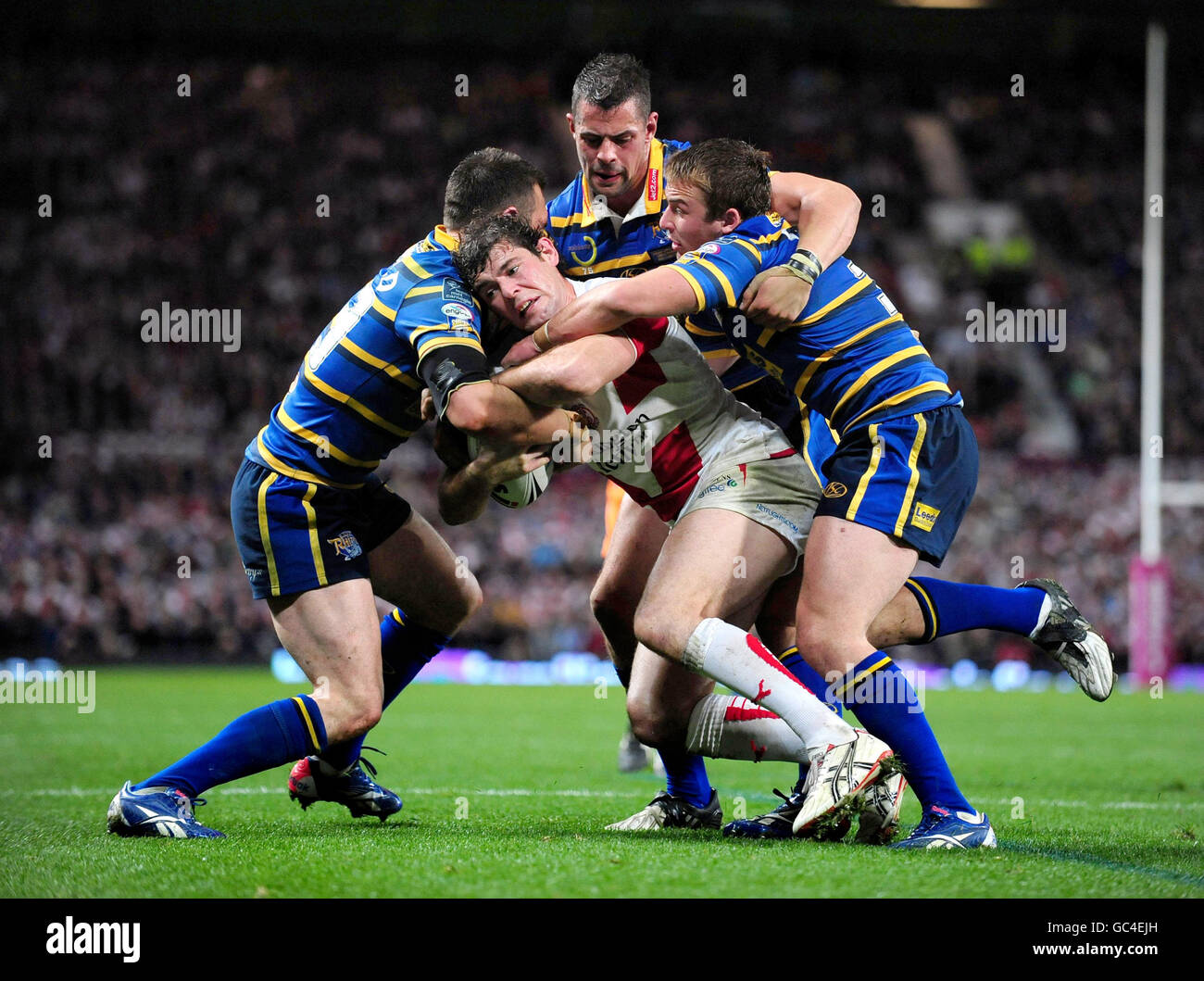 St Helens' Paul Wellens is tackled by Leeds Rhinos' Kevin Sinfield, Ian Kirke and Lee Smith during the Super League Grand Final match at Old Trafford, Manchester. Stock Photo