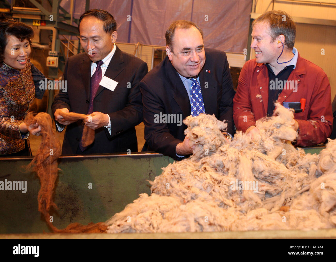 Blending team leader Ian Sneddon (right) from cashmere yarn manufacturer Todd & Duncan shows the cashmere wool to Mr Li Jianjun, the Mayor of the Municipal Government of Lingwu, Ningxia in China (second left), Madam Xiutian Tan, Consul General, Chinese Consulate in Edinburgh and Scottish First Minister Alex Salmond (second right). Stock Photo