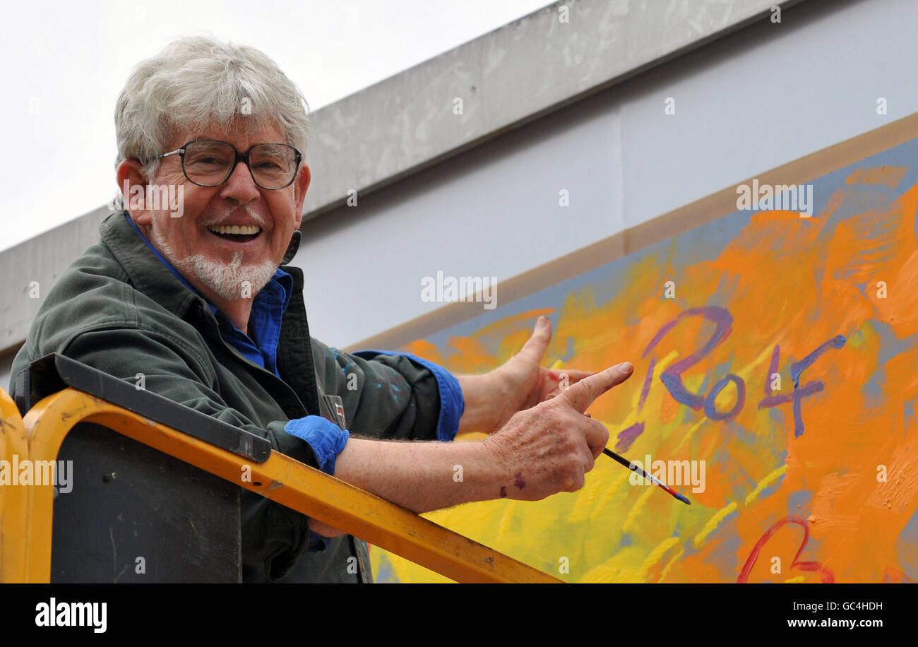 Celebrity artist Rolf Harris puts the finishing touches to a poster. Stock Photo