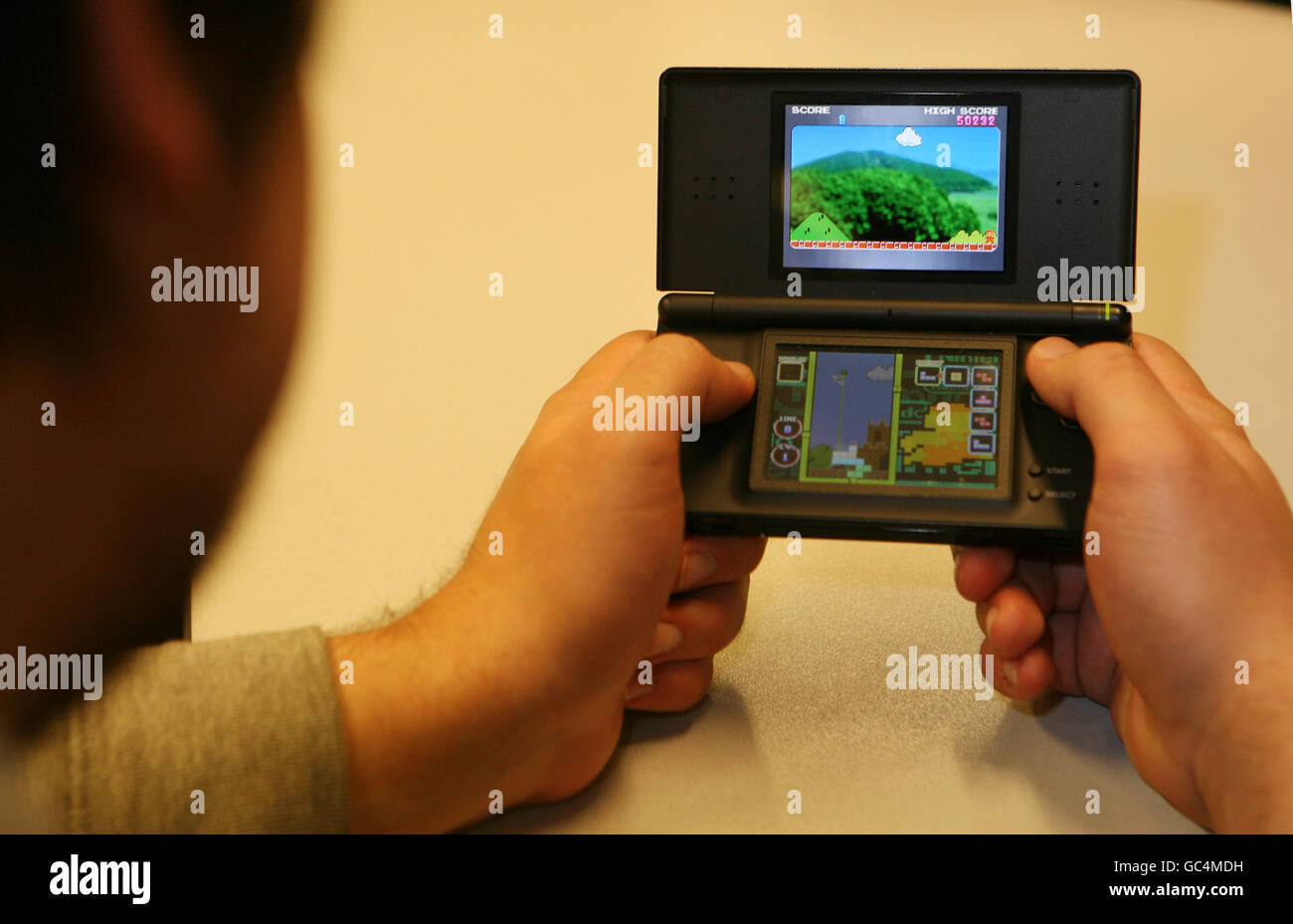 Computer game stock. A man plays a game on a Nintendo DS console. Stock Photo