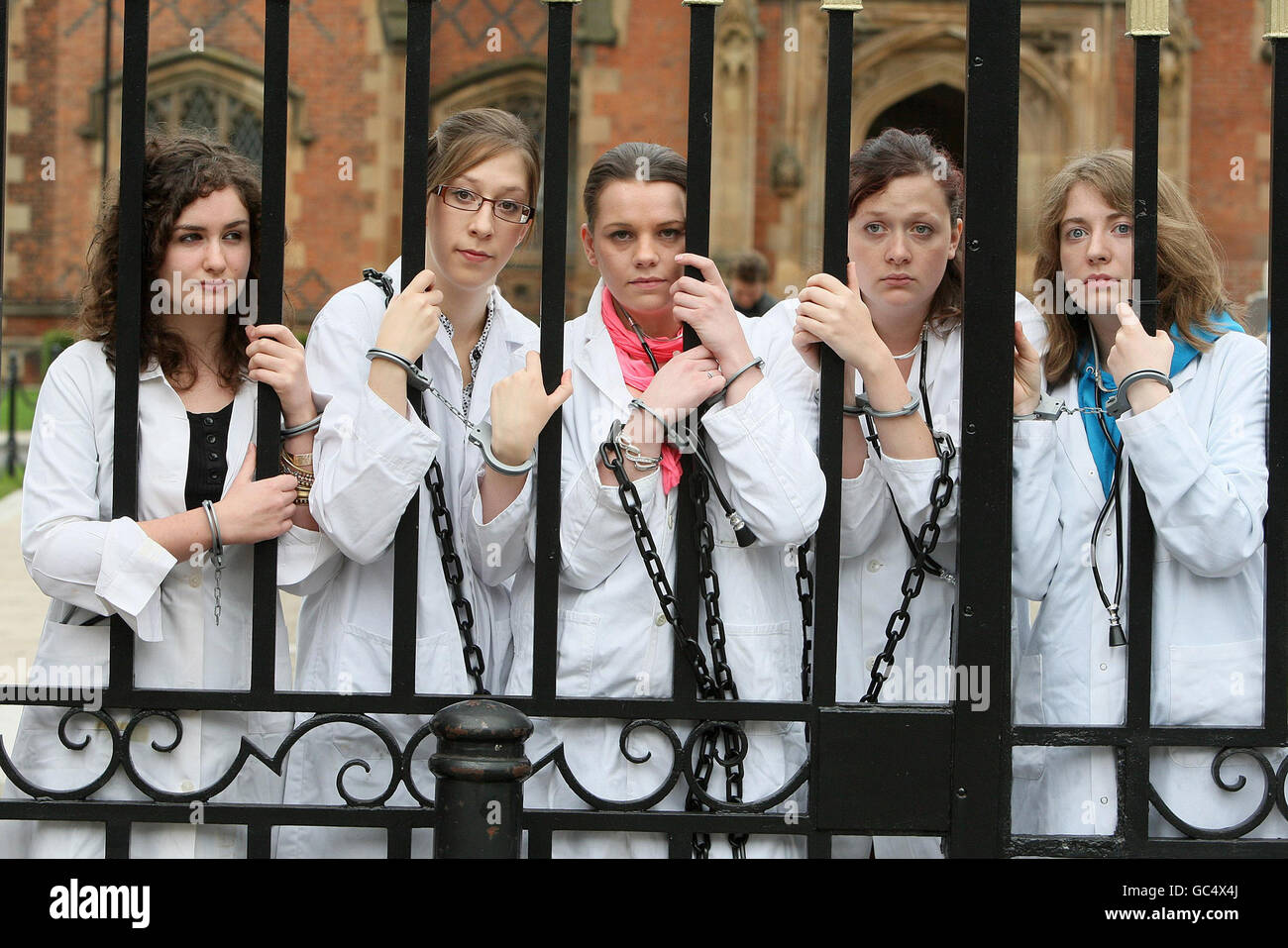 Individually handcuffed and chained together 24 Belfast students dressed as doctors protested at Queens University Belfast to highlight the plight of Dr Binayak Sen an award-winning paediatrician. Stock Photo