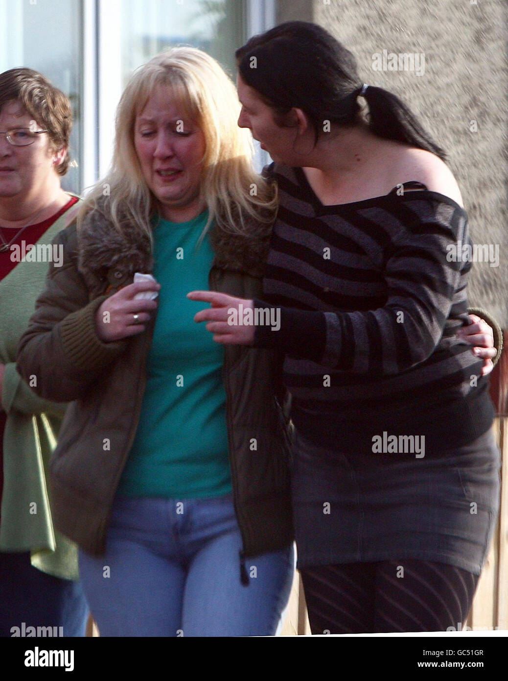 Two women console each other after visiting the scene in Devondale