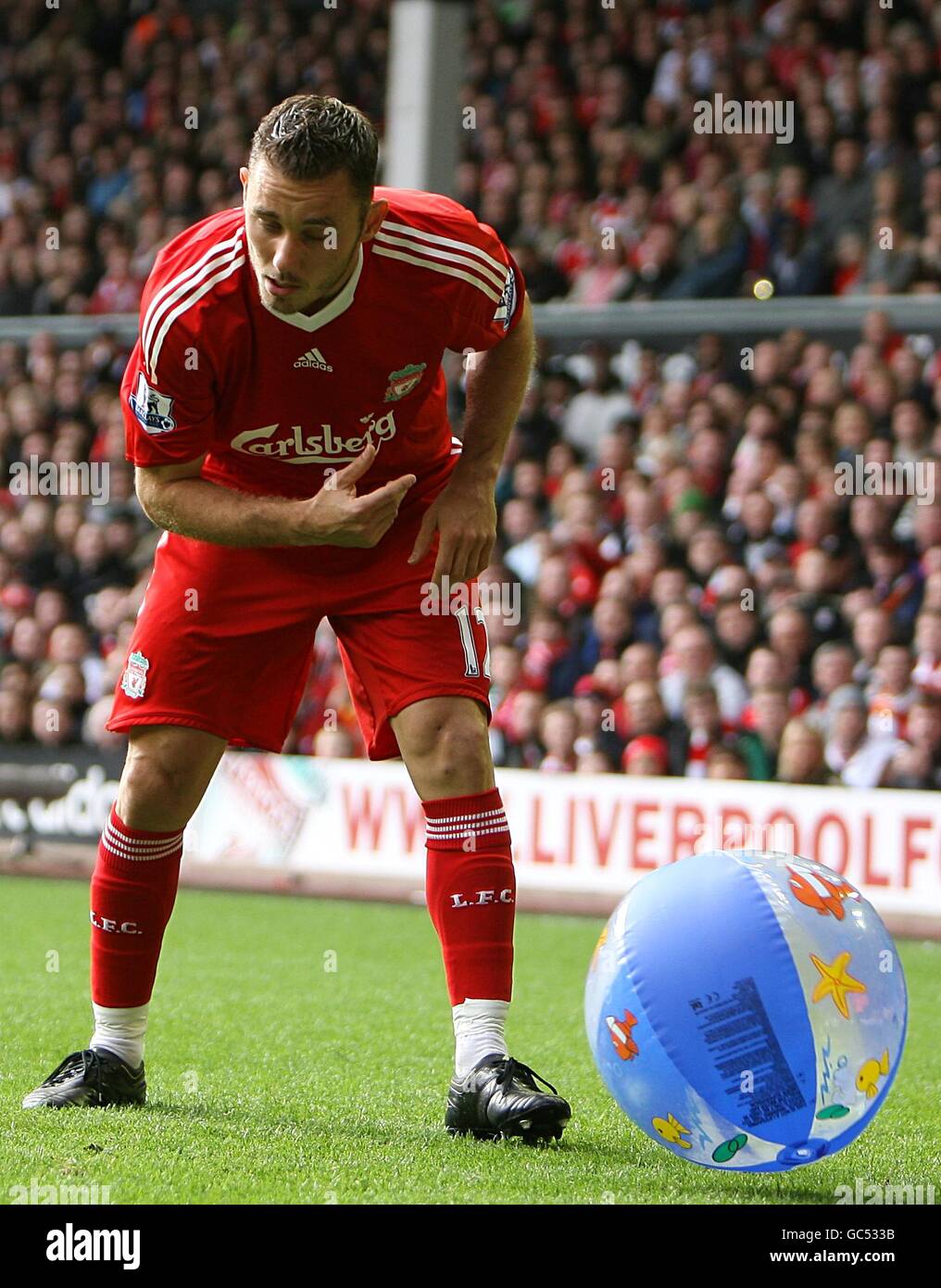 Liverpool's Fabio Aurelio removes a beach ball from the pitch at