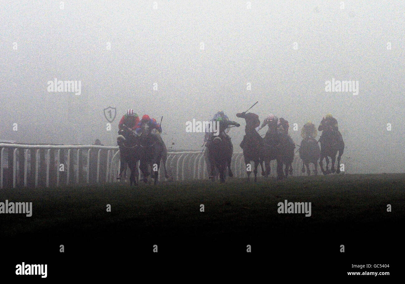 Runners and riders appear through thick fog as they run into the final furlong of the Turftv.co.uk Handicap at Catterick Races. Stock Photo