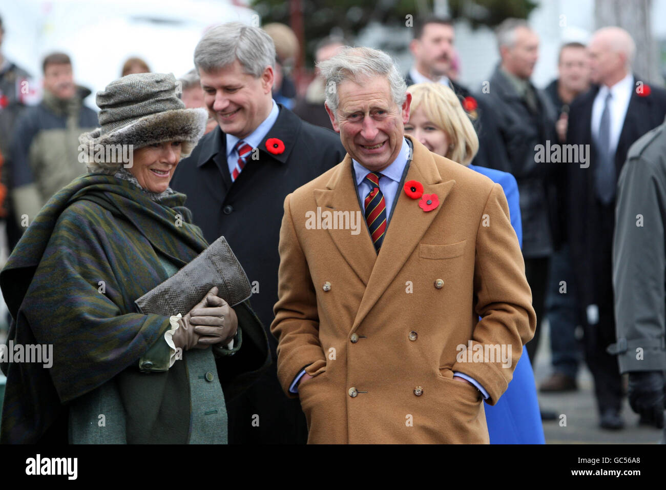 The Prince of Wales and the Duchess of Cornwall meet Prime Minister Stephen Harper (behind) during a visit to the Cupids Cove Plantation Archaeological site as part of their visit to Canada. Stock Photo