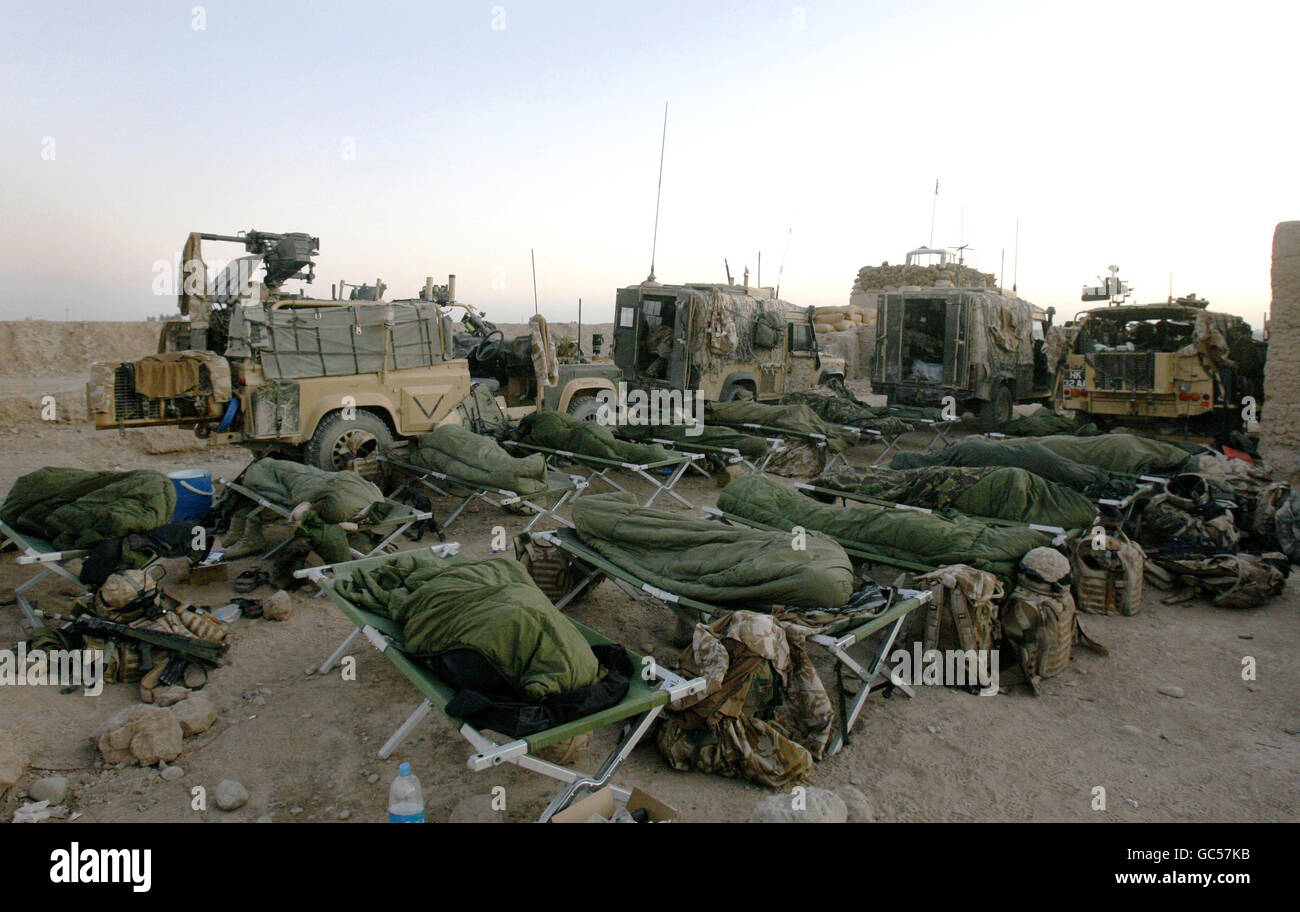 Soldiers from the Coldstream Guards sleep after a night on foot patrol mentoring the Afghan National Army in an area west of Lashkar Gah near to Patrol Base Bolan in Afghanistan. Stock Photo