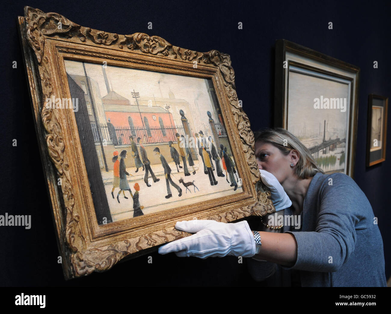 Rachel Hidderley of Christies hangs a painting by LS Lowry, entitled The Gateway, which was bought by the late actor Peter Barkworth for 57 in 1955 and will go on sale on Thursday, 12 November for an estimated 150,000 - 250,000. Stock Photo