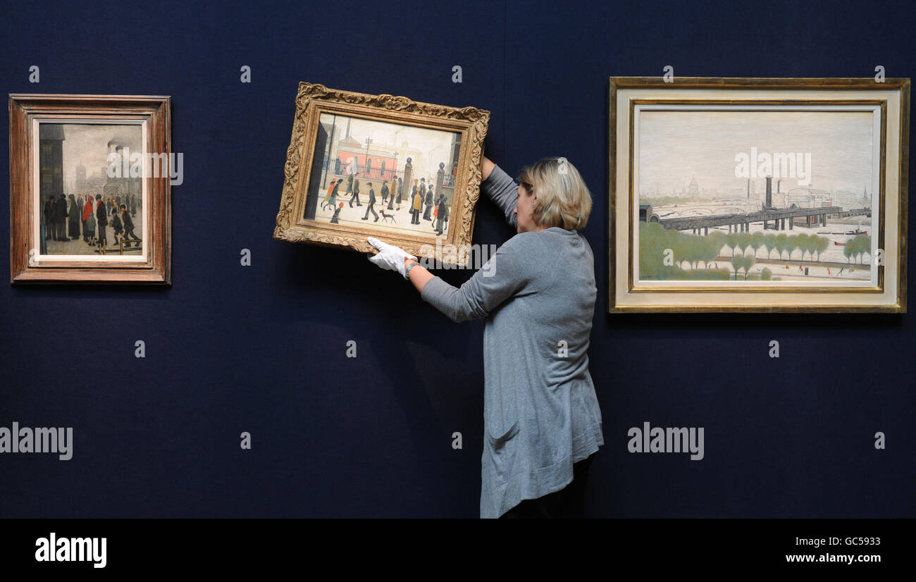 Rachel Hidderley of Christies hangs a painting by LS Lowry, entitled The Gateway, which was bought by the late actor Peter Barkworth for 57 in 1955 and will go on sale on Thursday, 12 November for an estimated 150,000 - 250,000. Stock Photo