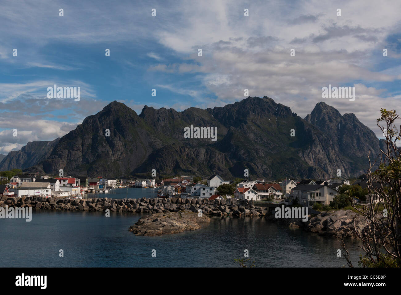 View of Henningsvær village in Lofoten Islands, Norway with mountains in background.Photographed in summer Stock Photo