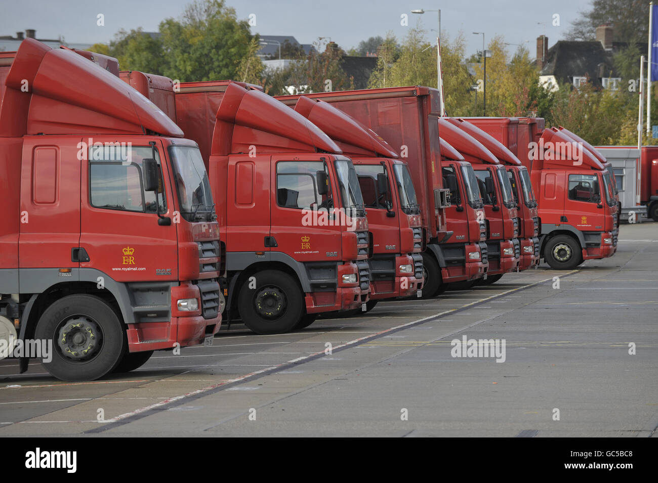 Royal Mail delivery lorries stand idle at the Royal Mail sorting office