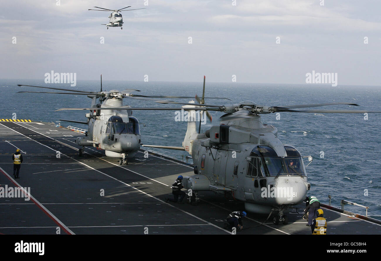 Merlin helicopters from the Royal Navy land on HMS Illustrious before she sails into Liverpool, for the Fly Navy 100 event which is celebrating a 100 years of Naval aviation. Stock Photo