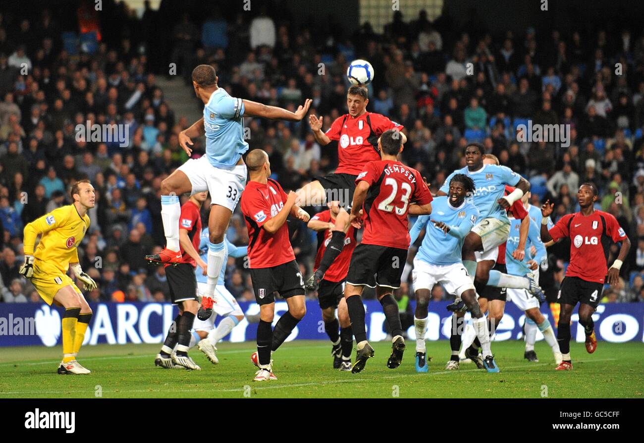 Soccer - Barclays Premier League - Manchester City v Fulham - City of Manchester Stadium. Fulham's Chris Baird (centre top) clears the ball from danger Stock Photo