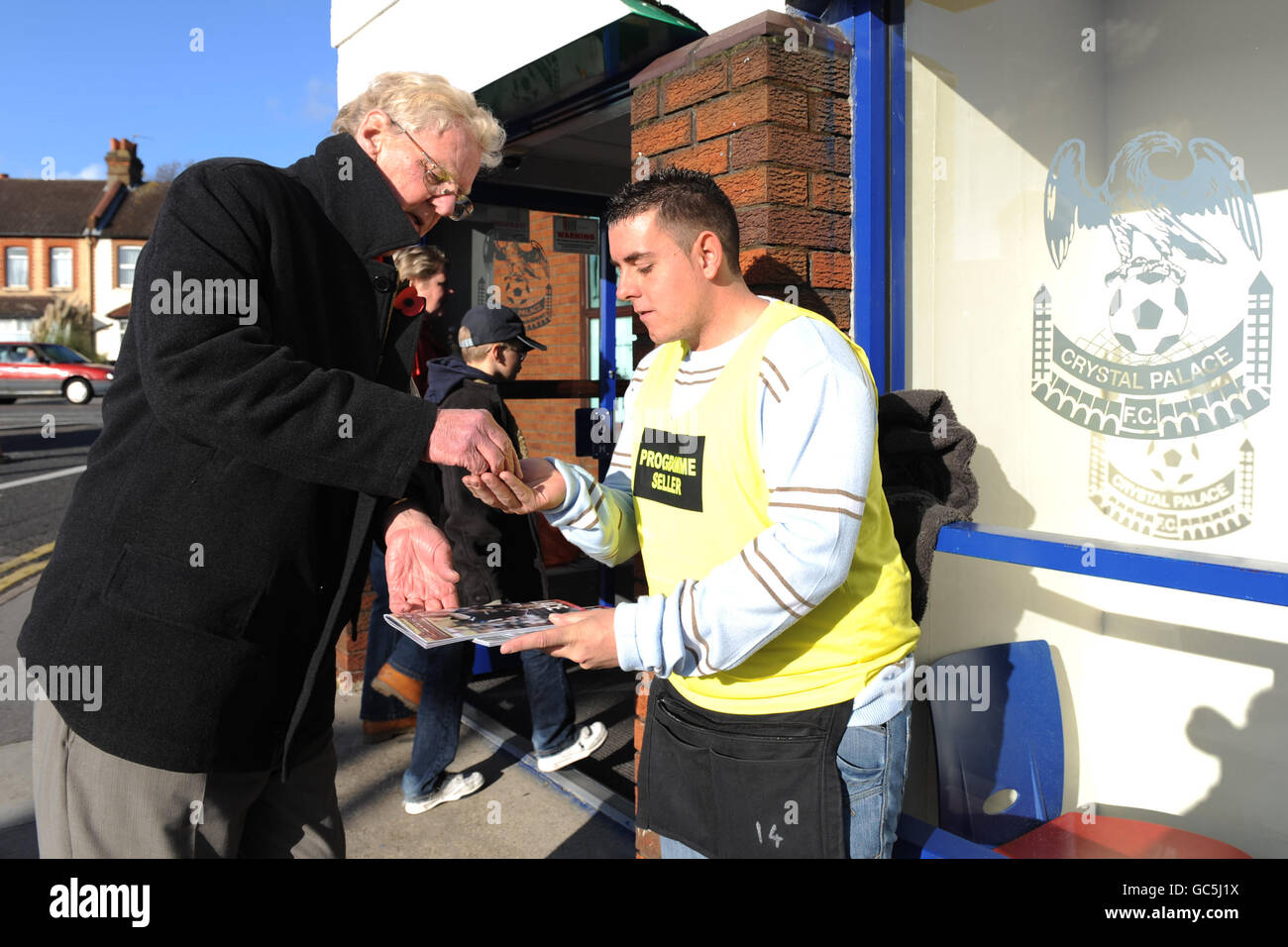 A fan buys a match day programme outside the ground prior to kick off Stock Photo