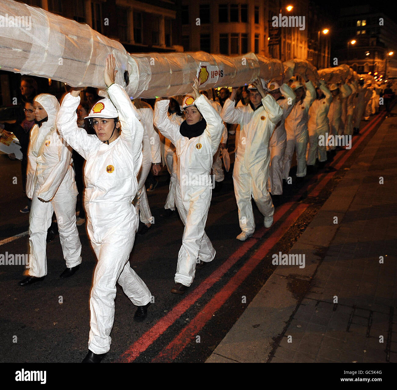 Environmental campaigners organised by Amnesty International carry a tube through Hoxton to protest against the activities of oil giant Shell in the Niger Delta. Stock Photo