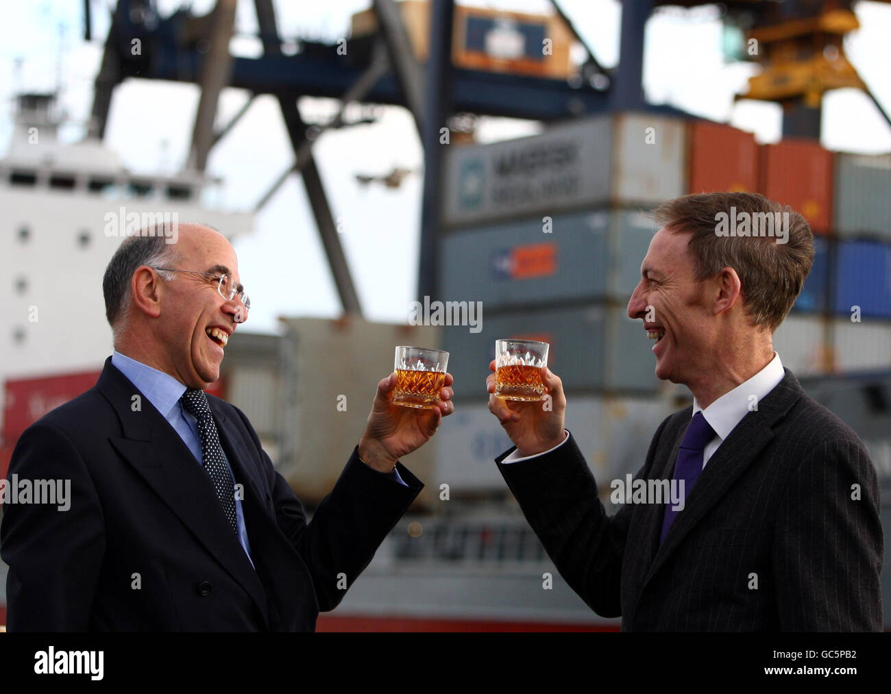 Scottish Secretary Jim Murphy (right) raises a glass of whisky with the chief executive of the Scotch Whisky Association Gavin Hewitt, as the new Scotch whisky regulations come into effect, at Grangemouth Docks, Falkirk, Scotland. Stock Photo