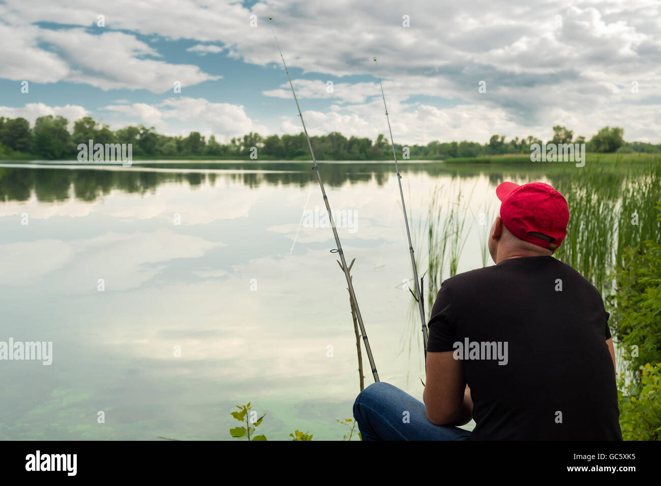 Man catches a fish in pond Stock Photo - Alamy