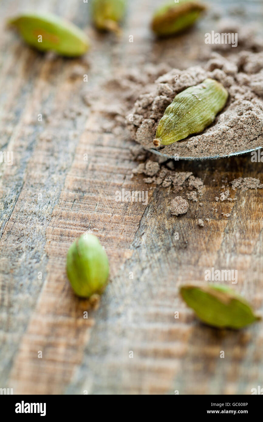 Scattered pods and spoon of powdered cardamom Stock Photo Alamy