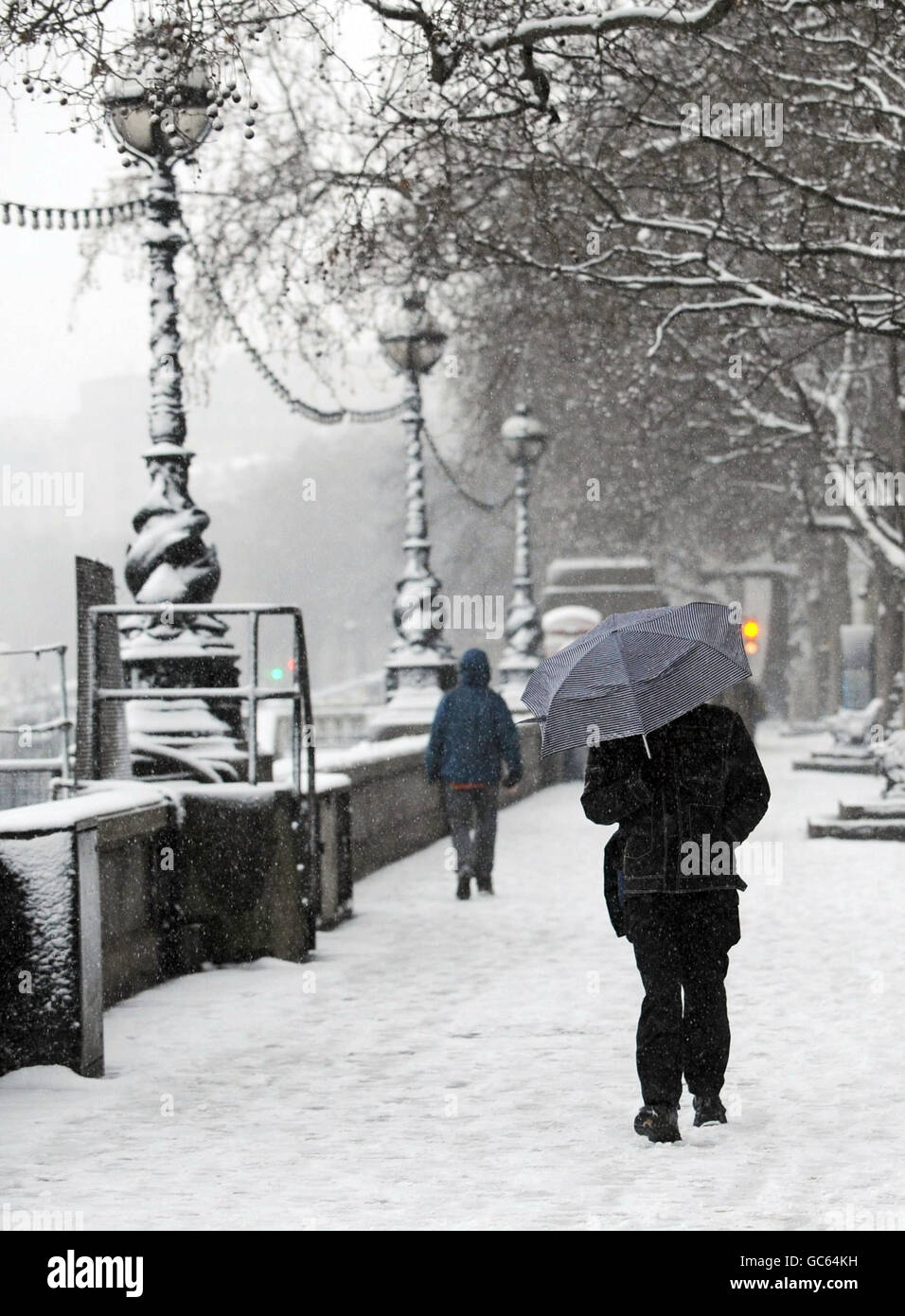 Commuters on the Embankment in London this morning brave blizzard conditions on their way to work. Stock Photo