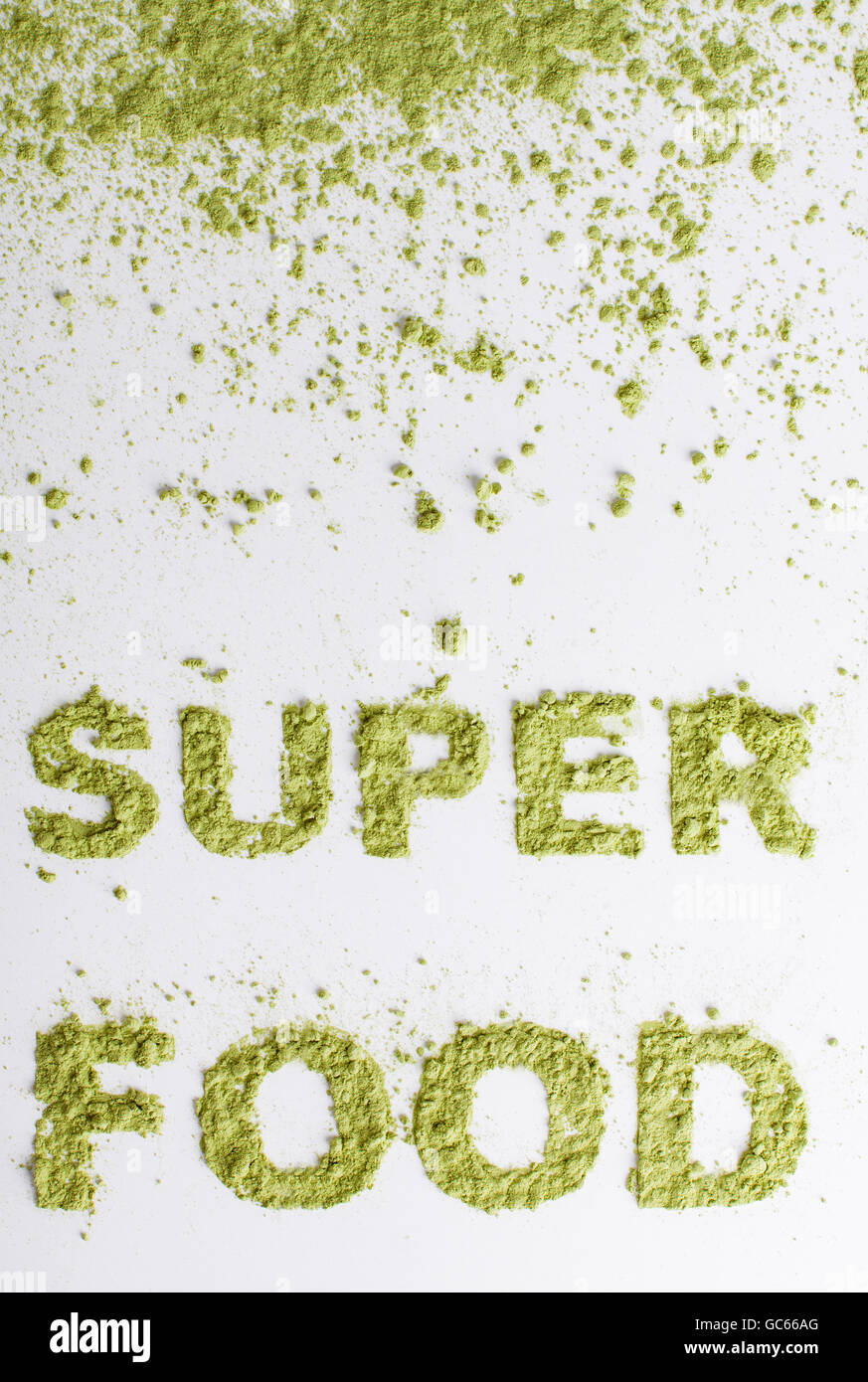 Word superfood piled of  green powder of barley grass on white background. Stock Photo