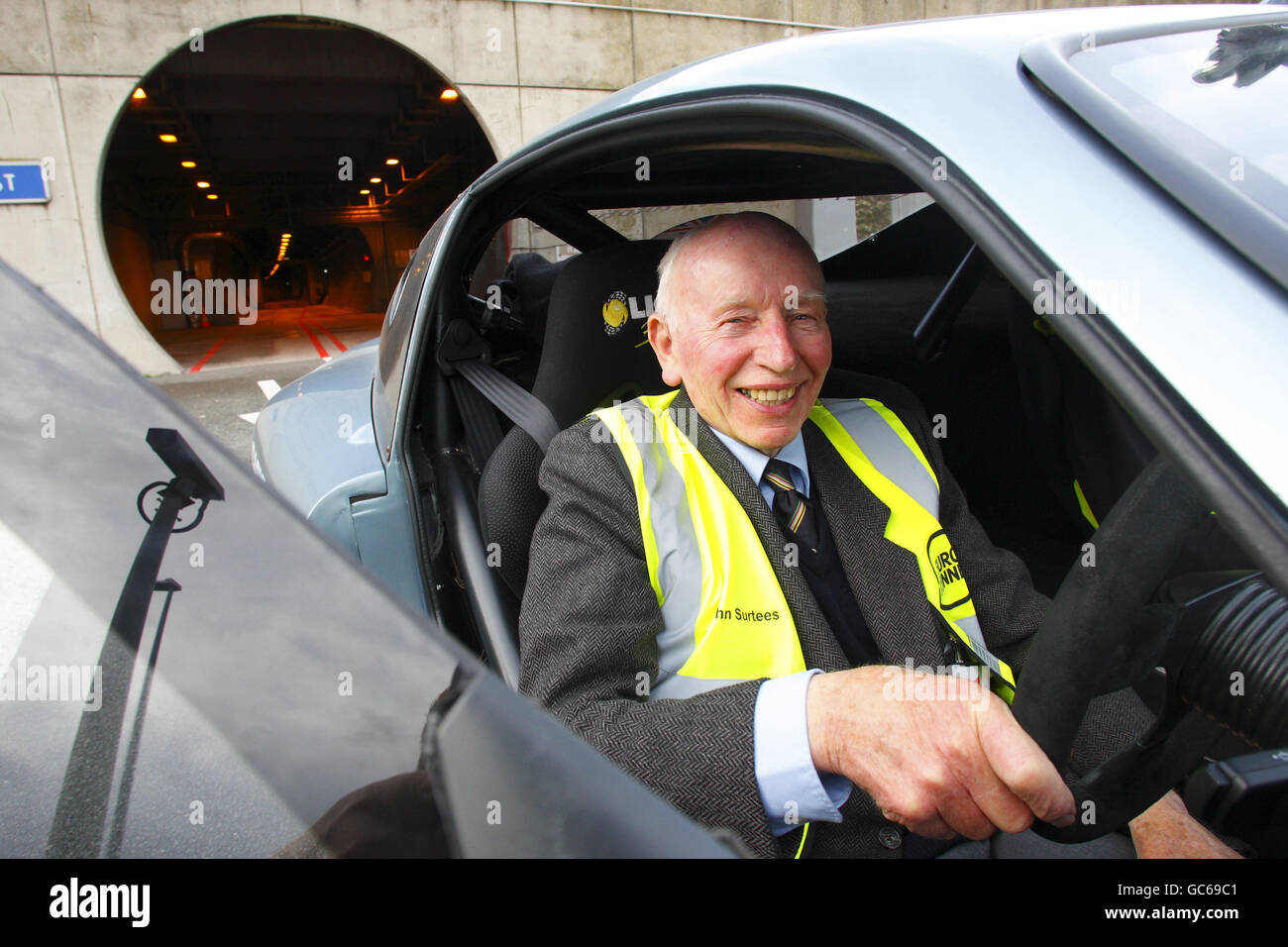Former Formula One World Champion John Surtees emerges after being the first person to drive a sports car the full length of the Channel Tunnel from Folkestone in Kent to Coquelles in France. Stock Photo