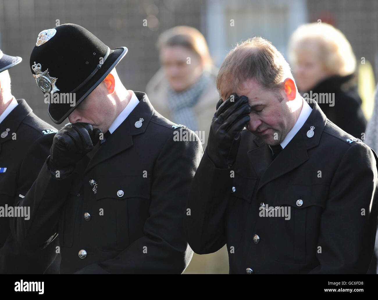 A police guard of honour watches as the coffin of PC Bill Barker