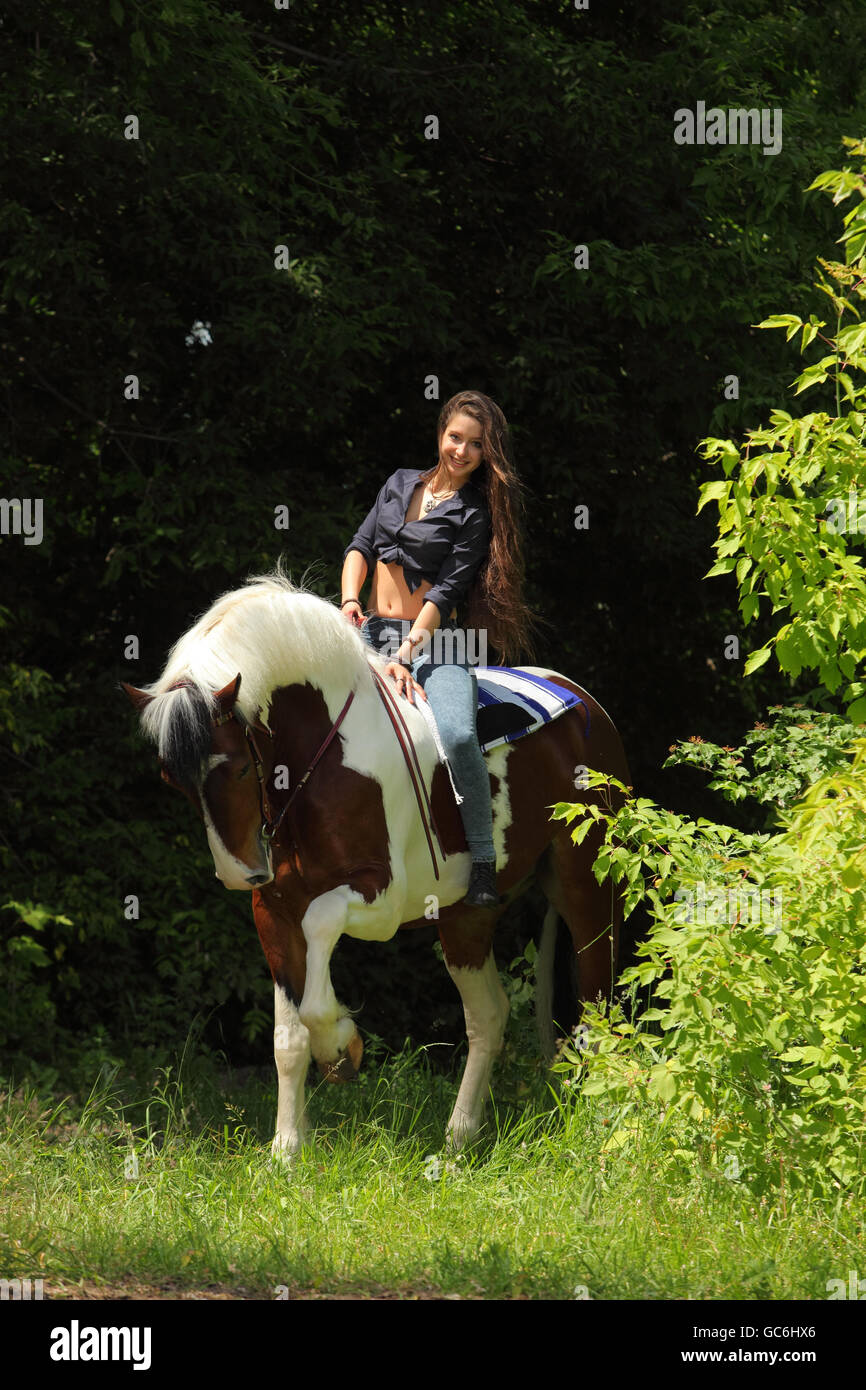 Pretty cowgirl bareback riding painted horse Stock Photo