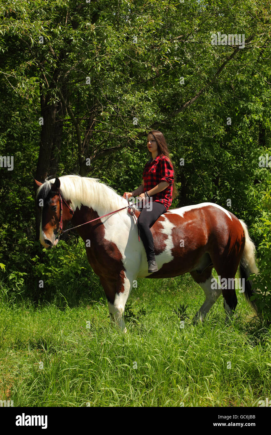 Pretty cowgirl bareback riding painted horse Stock Photo