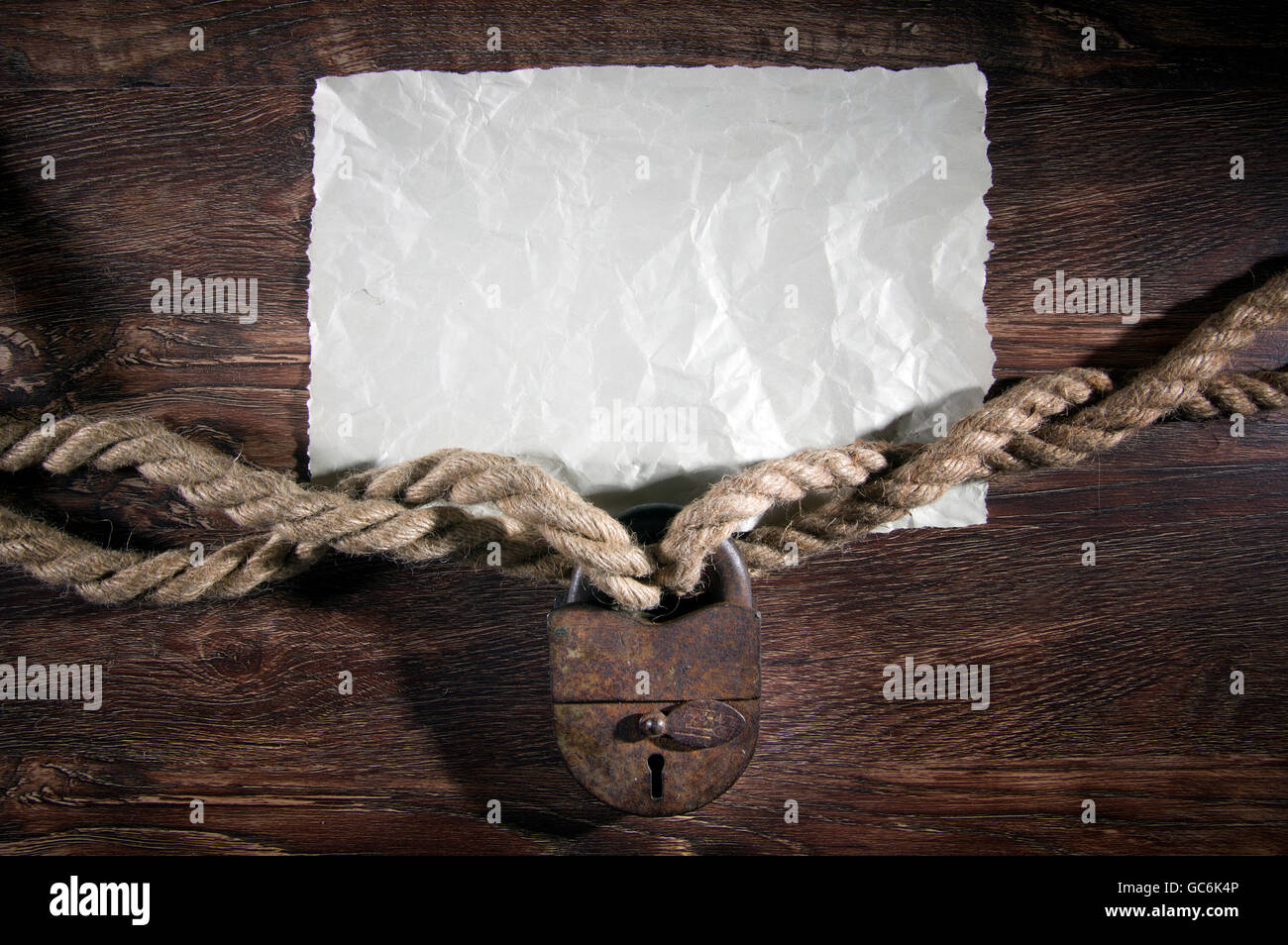 Old rusty lock with rope on wood background Stock Photo - Alamy