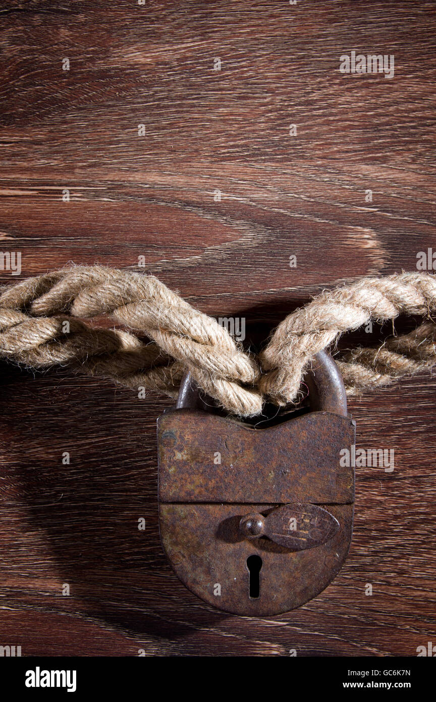 Old rusty lock with rope on wood background Stock Photo - Alamy