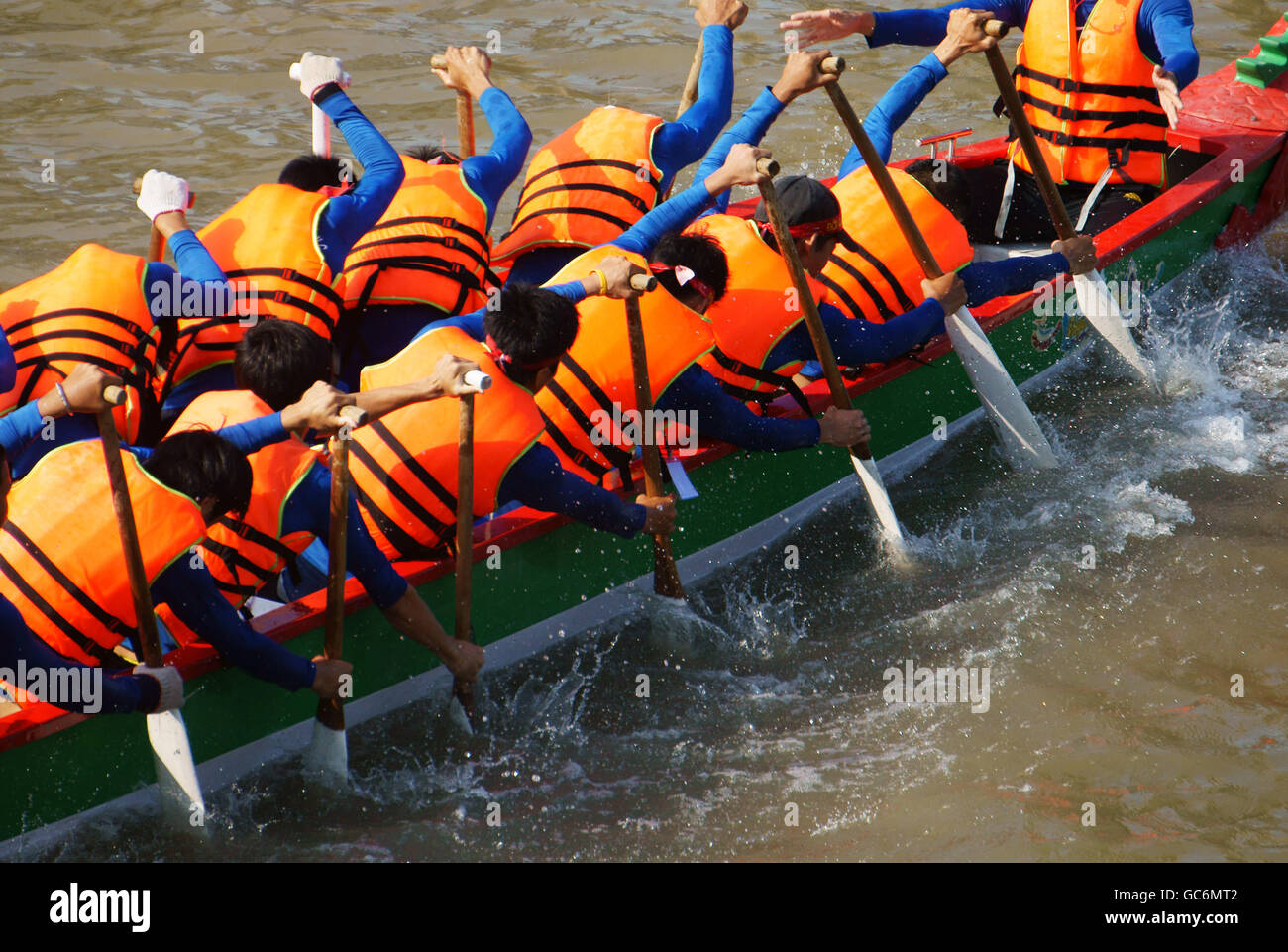 Teamwork of man, rowing dragon boat in racing, try to row with high speed and championship spirit, rhythm of paddle so dynamic Stock Photo