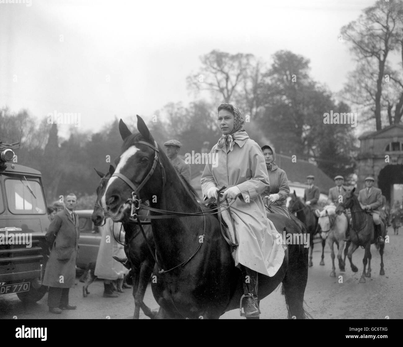 Queen Elizabeth II (wearing a mackintosh and headscarf) in Badminton Great Park as she attends the second day of the Badminton Horse Trials. Behind her is Princess Margaret and the Duke of Beaufort. Stock Photo