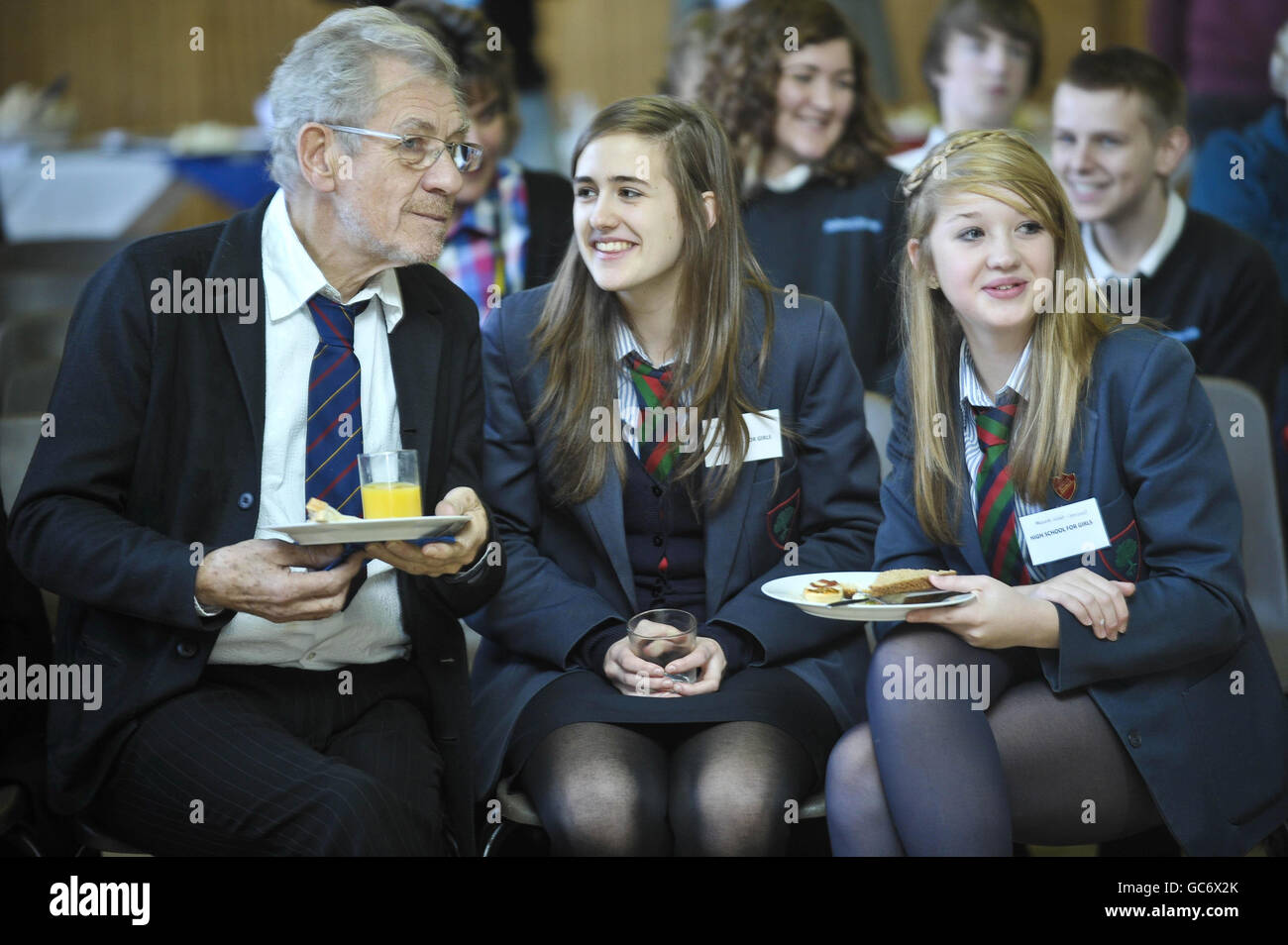 (Left - right) Sir Ian McKellan talks with Francesca Lane, aged 15, and her friend Alanna Collier-Cromwell, also 15, both from High School for Girls in Gloucester, who are visiting Severn Vale School to see a play with an anti-homophobic bullying message. Stock Photo