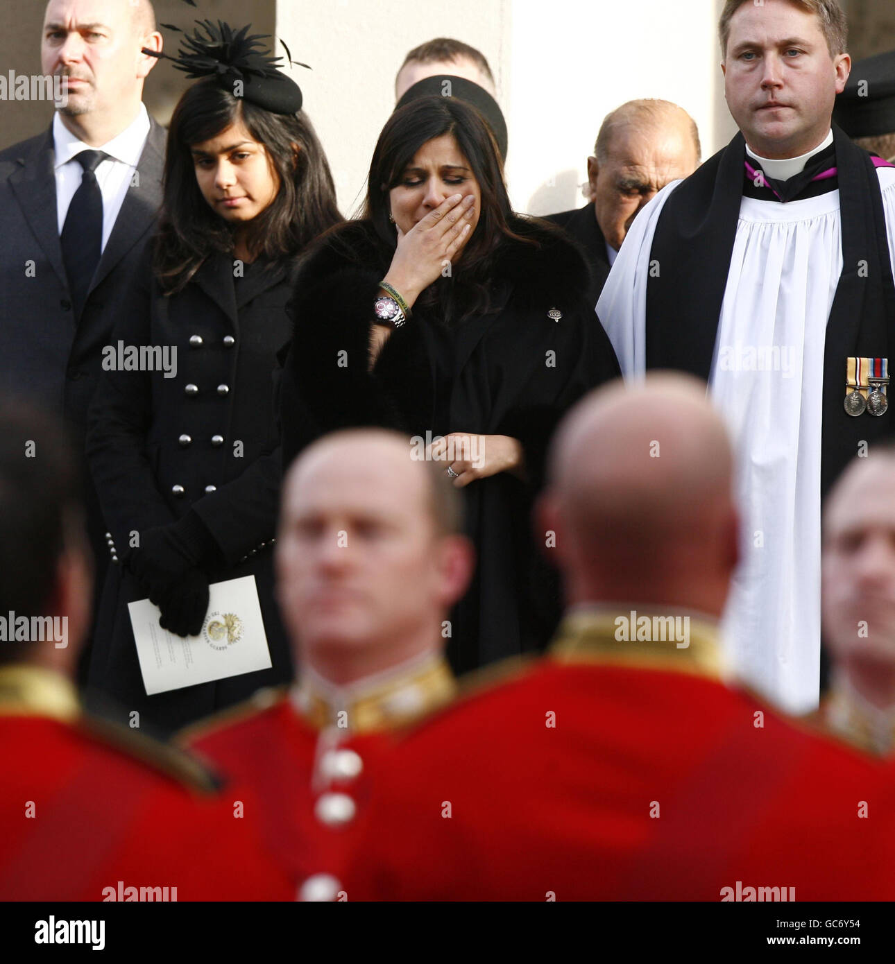 Nausheen Chant (centre), the widow of Warrant Officer Class 1 Darren Chant, 40, Regimental Sergeant Major of 1st Battalion Grenadier Guards, watches the coffin of her husband be carried away during his funeral at The Guards Chapel, Wellington Barracks, in central London. Stock Photo