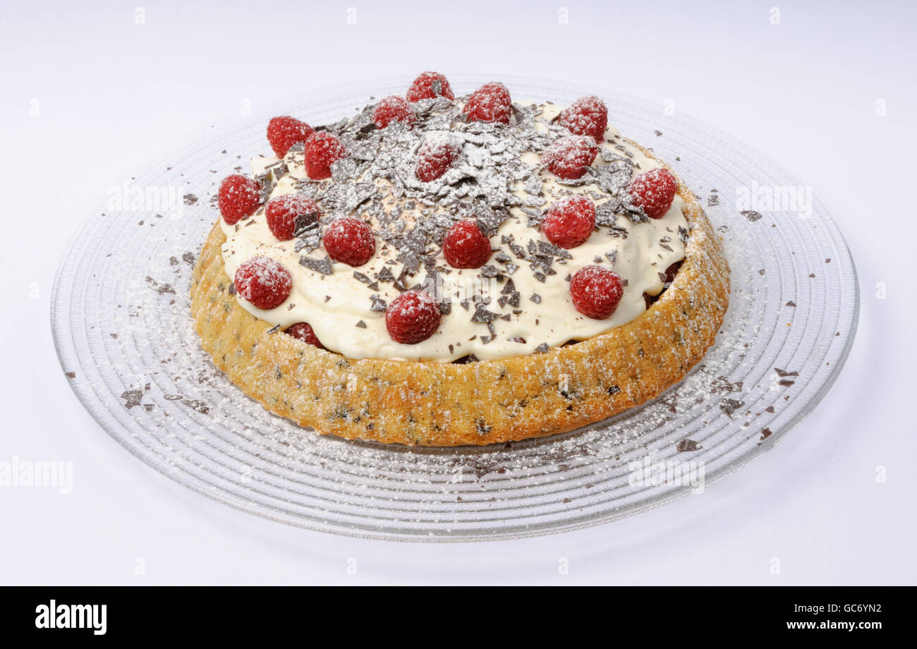Raspberry cheese torte with chocolate flakes and powdered sugar on a glass plate Stock Photo
