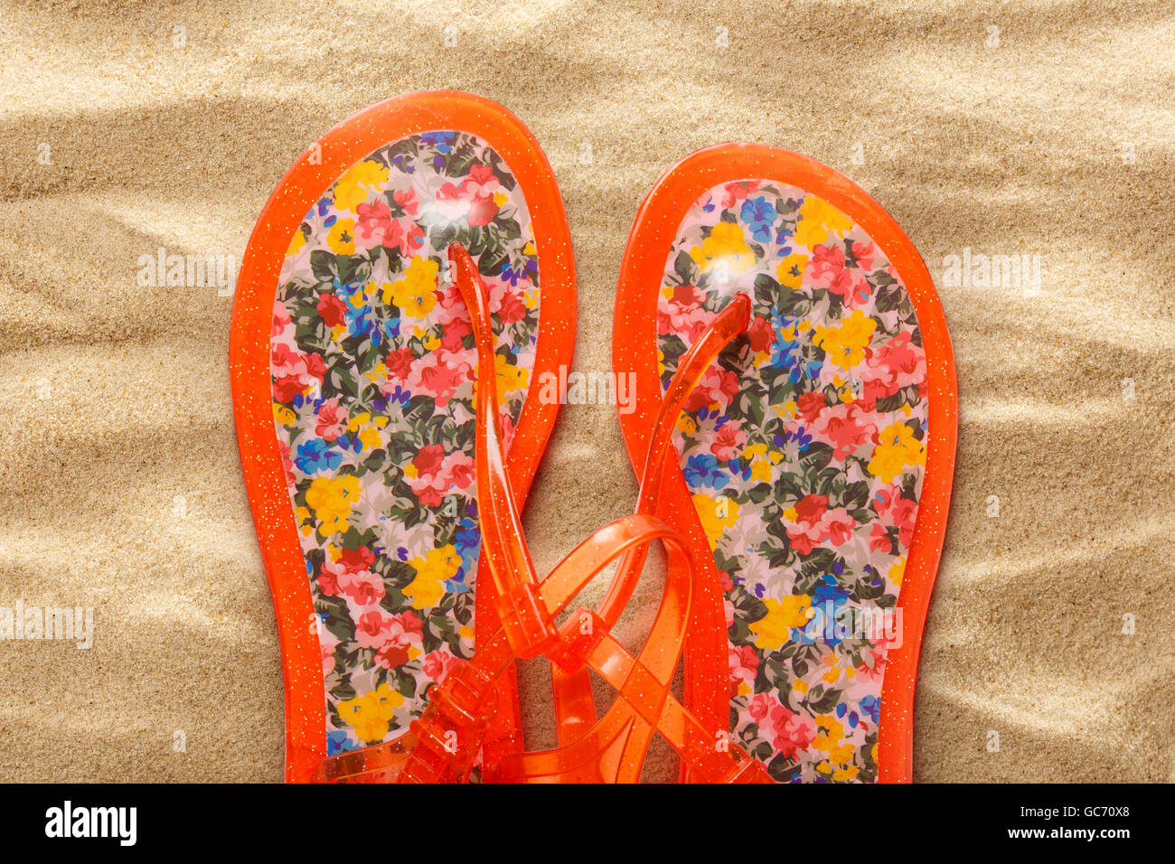Female beach sandals on sand background closeup Stock Photo - Alamy