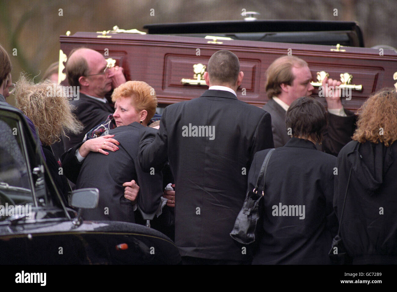 ELIZABETH CAPPER, MOTHER OF MURDERED TEENAGER SUZANNE CAPPER, COMFORTS ONE OF HER SONS, STEVE, AS SUZANNE'S COFFIN ENTERS THE CHURCH AT BLACKLEY CEMETRY. Stock Photo