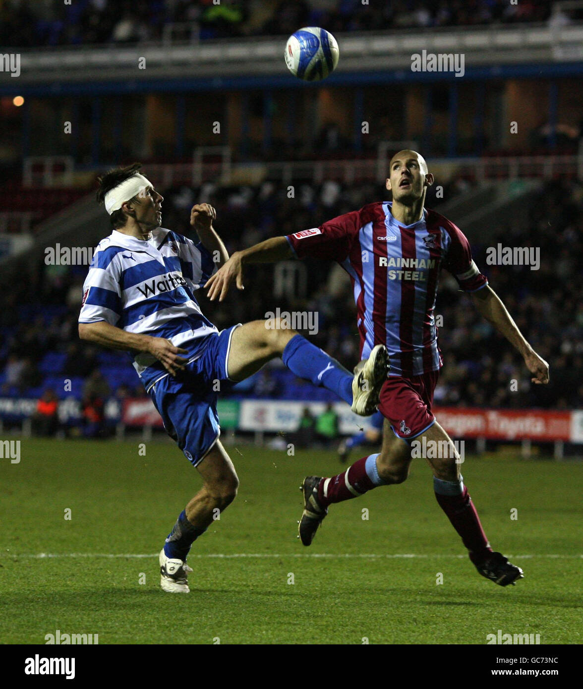 Reading's Grzegorz Rasiak and Scunthorpe United's Rob Jones battle for the ball during the Coca-Cola Championship match at the Madjeski Stadium, Reading. Stock Photo