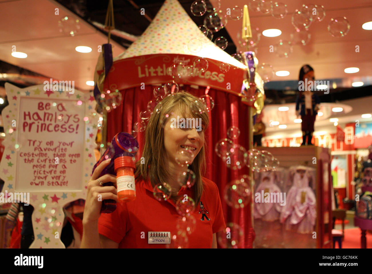 A Hamleys staff member plays with a bubble machine at the opening of