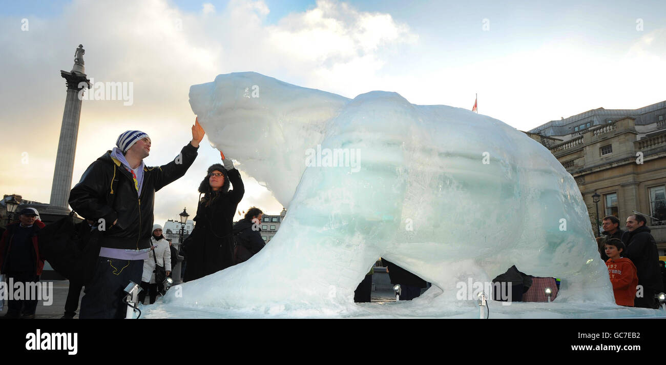 Members of the public touches a life sized 'Ice Bear' sculpture in London's Trafalgar Square, as part of the WWF's campaign to highlight the plight of the bears in the Arctic where melting icecaps are threatening their survival. Stock Photo