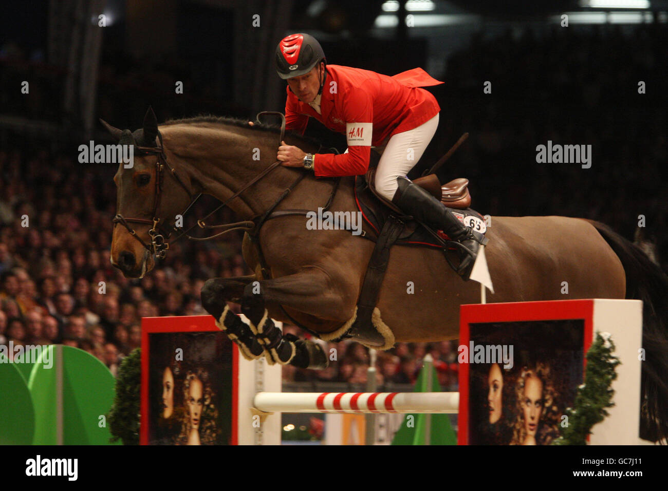 Switzerland's Pius Schwizer riding Carlina competes in the Rolex FEI Worldcup Jumping during the London International Horse Show at the Olympia Exhibition Centre, London. Stock Photo