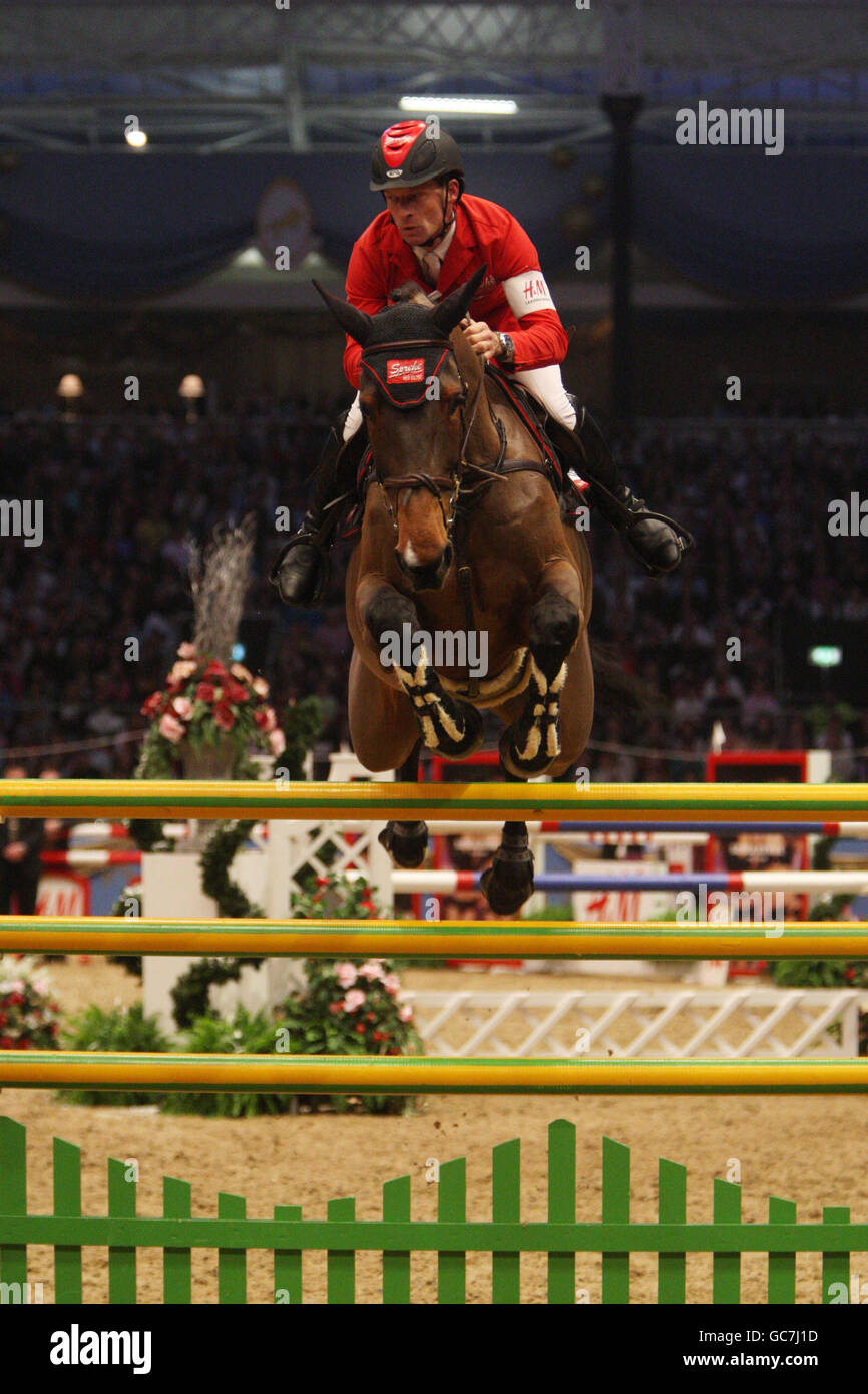 Switzerland's Pius Schwizer riding Carlina competes in the Rolex FEI Worldcup Jumping during the London International Horse Show at the Olympia Exhibition Centre, London. Stock Photo