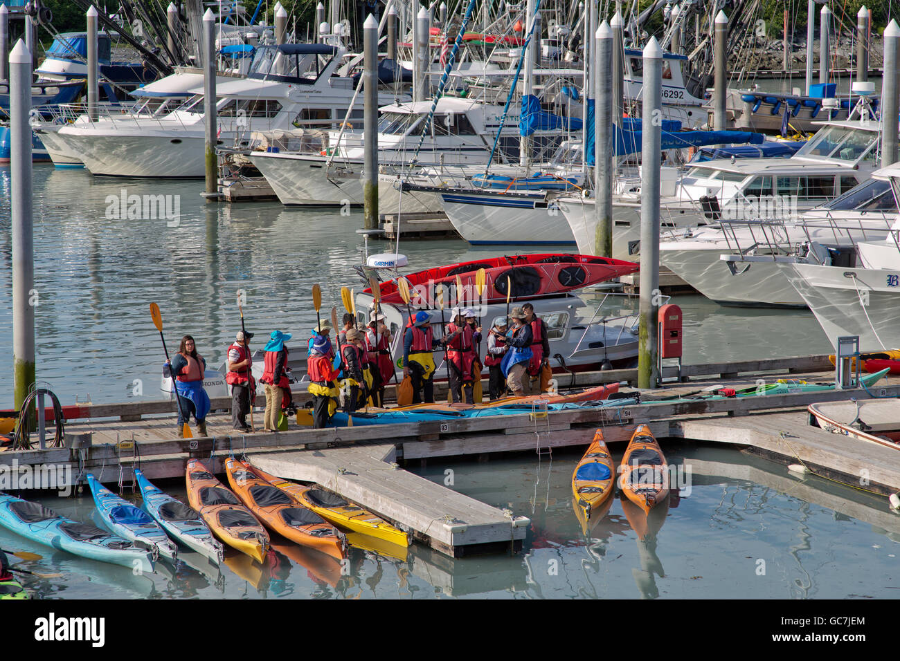 Kayakers, young men & women preparing to depart Valdez Small Boat Harbor. Stock Photo