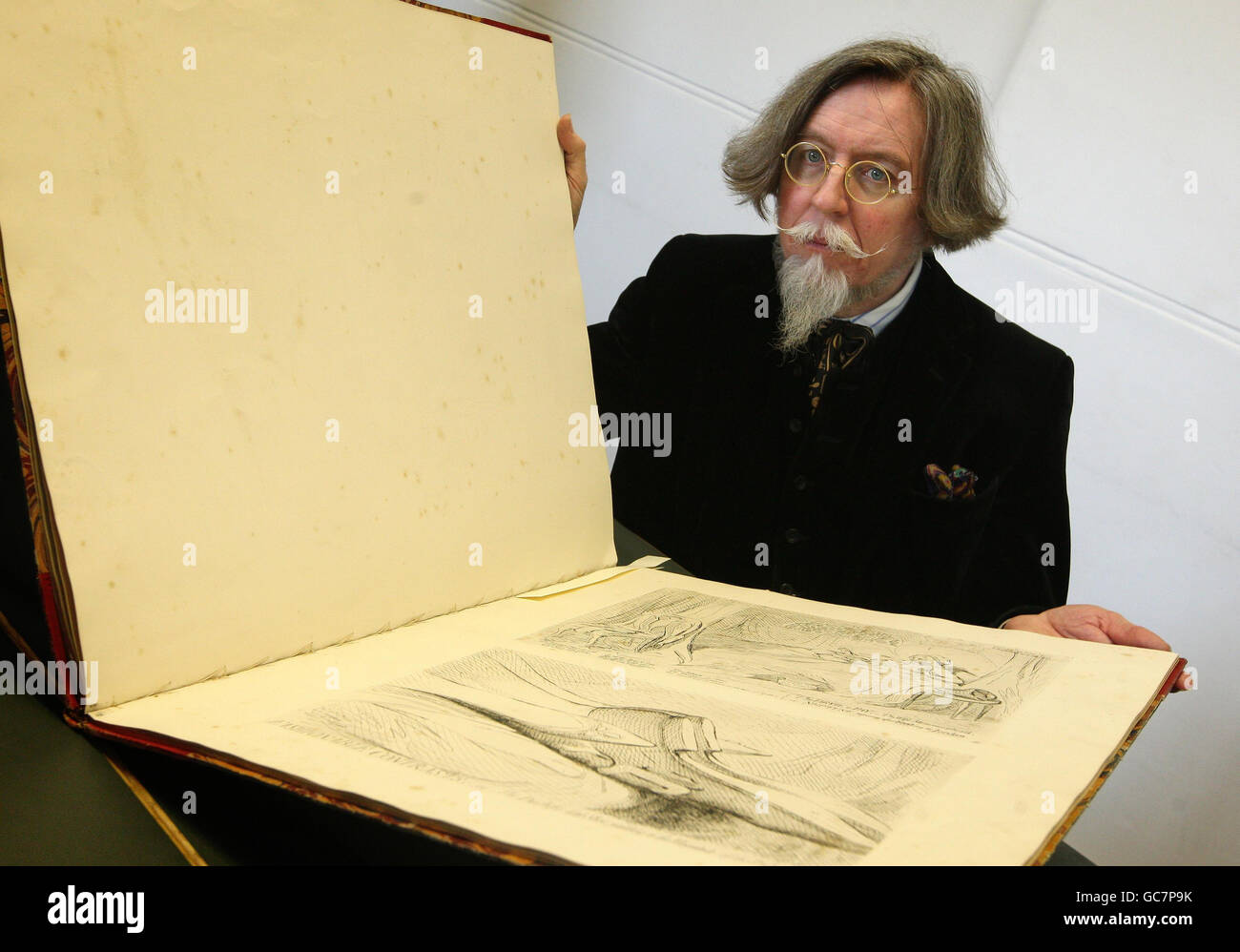 Stephen Calloway, Curator of Prints in the Word and Image Department of the Victoria and Albert Museum, London, examines a book of cartoons by British caricaturist James Gillray, which were originally censored in the 19th century, and lay hidden in government archives for over 100 years. Stock Photo