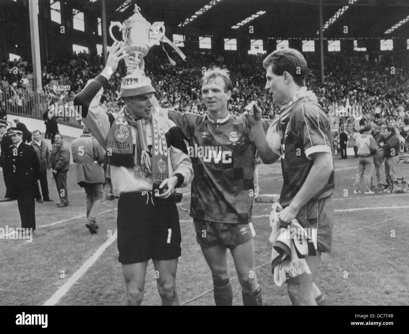Aberdeen's goalkeeper Theo Snelders (l), captain Alex McLeish (c) and Brian Irvine (r) celebrate with the cup after beating Celtic 9-8 on penalties. Stock Photo