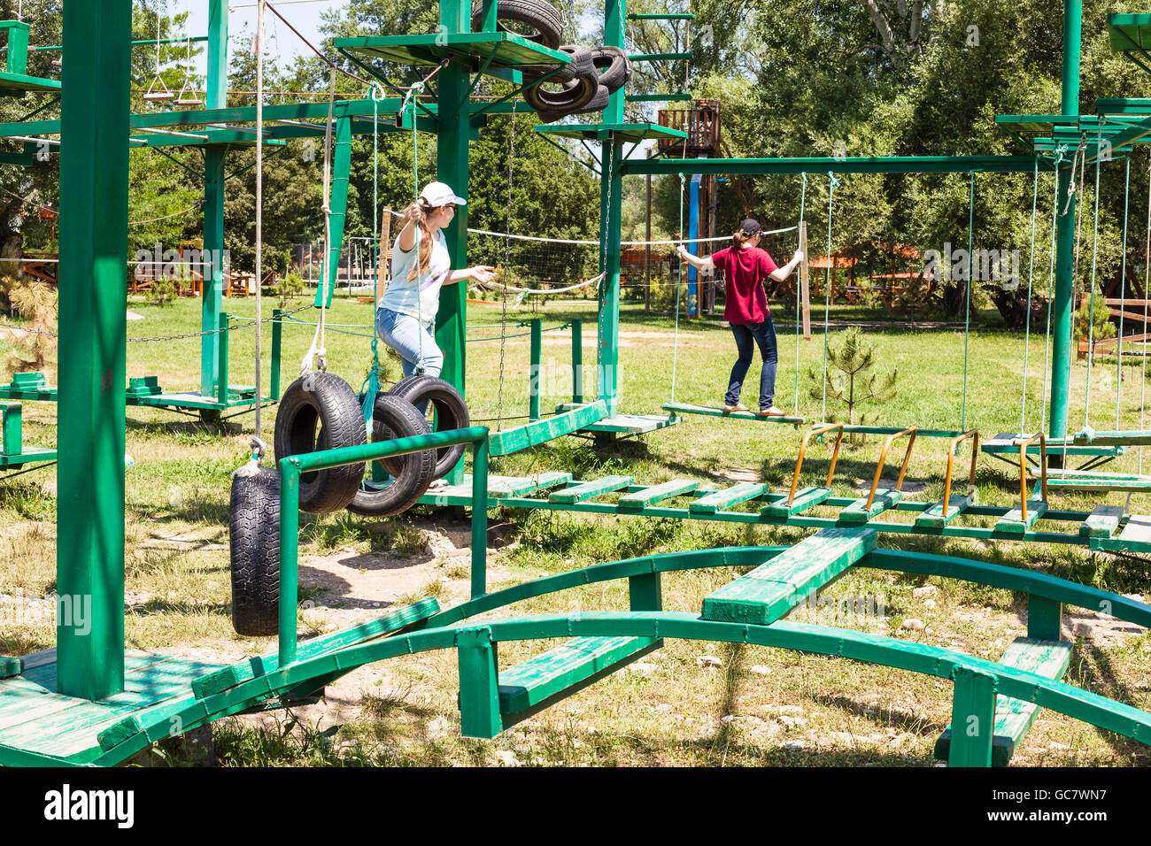 two girls pass an outdoor obstacle course in sunny summer day Stock Photo