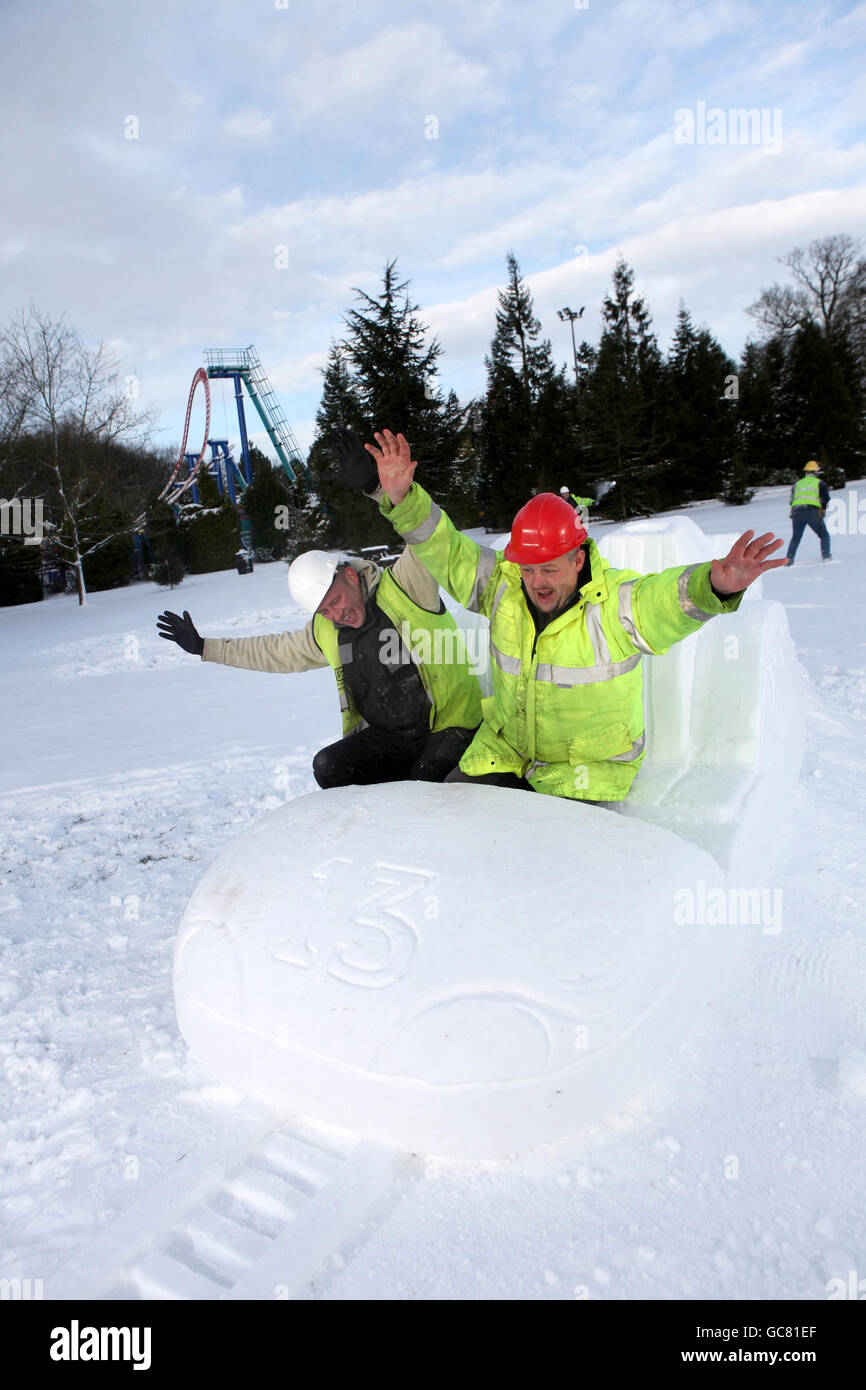 Workmen take a break from the construction of new ride, 'Th13teen' at the Alton Towers Resort in Staffordshire, to play with a snow sculpture version of the roller coaster carriage that they helped to build. Stock Photo