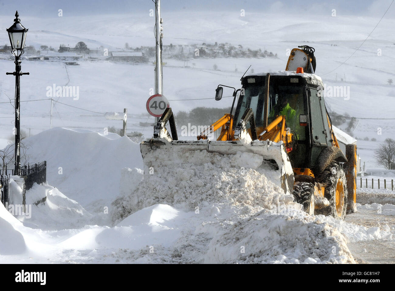 A snow plough removes deep snowdrifts near Oldham as heavy snowfalls continue across most parts of the UK. Stock Photo