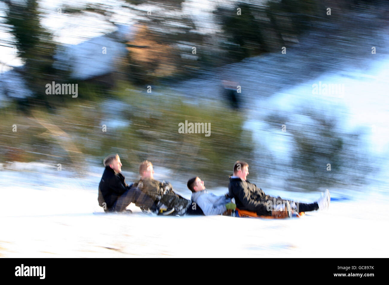 Kids sledge in the snow on Mousehold Heath, Norwich, following heavy snow falls. Stock Photo