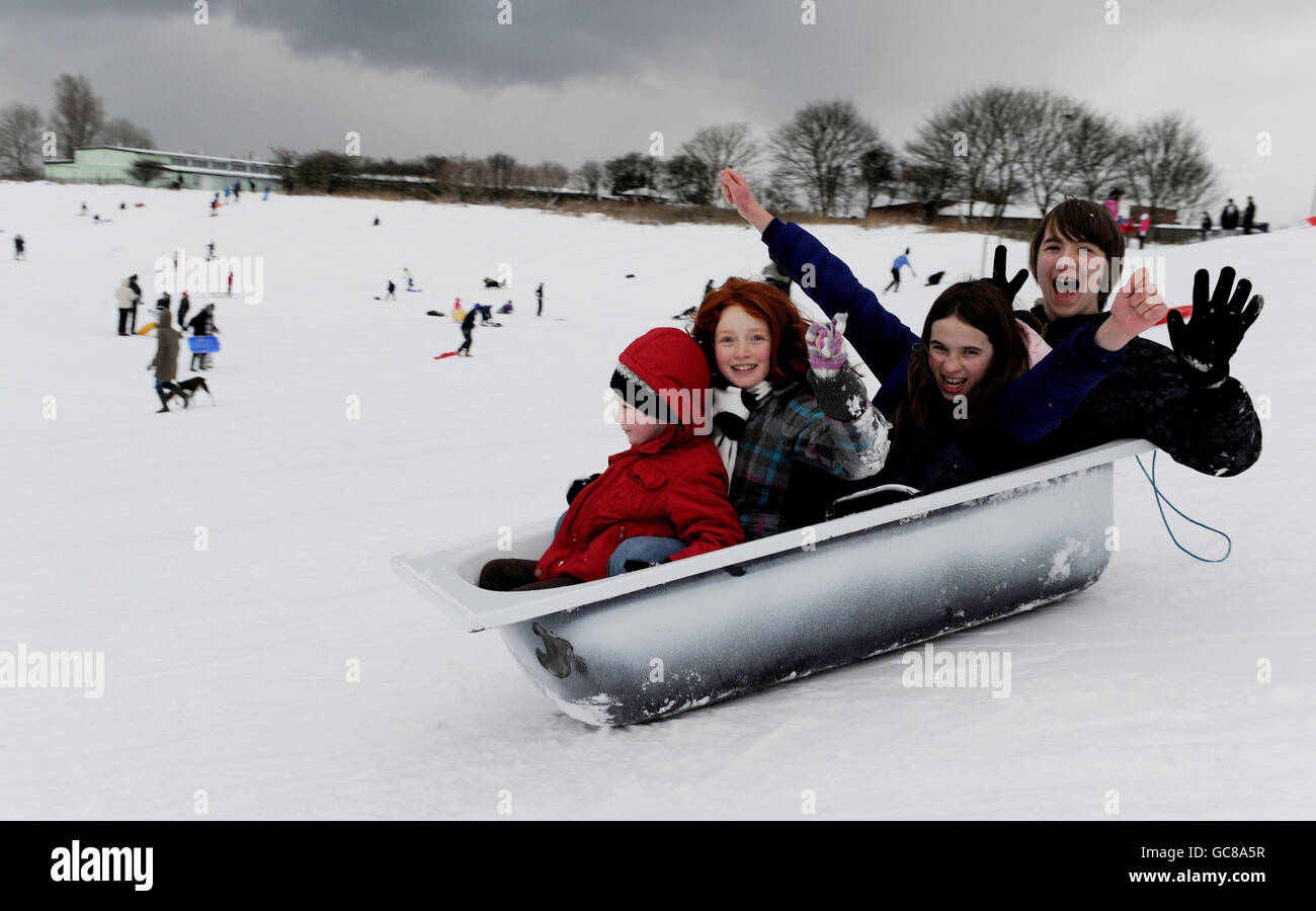 Sledgers use an old bath tub to sledge in Whitley Bay in North Tyneside, as temperatures continued to fall throughout Britain. Stock Photo